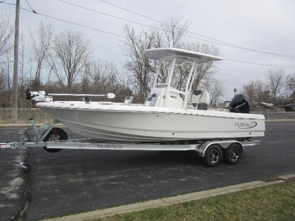 Slide: The Image of 2024 Robalo 226 Cayman boat on a trailer in a parking lot. - 0