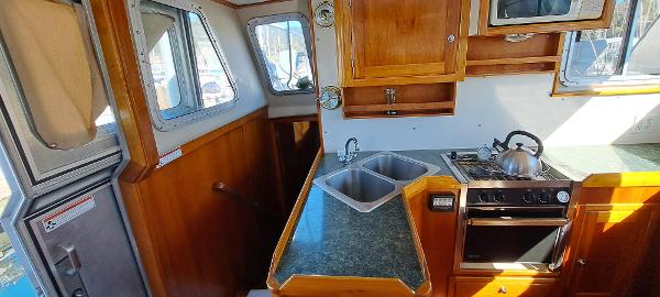 Slide: The Image of 1999 Rozema Boat Works Custom 42 kitchen with wood cabinetry and dual sinks. - 10