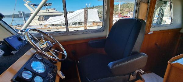 Slide: The Image of Interior helm of 1999 Rozema Boat Works Custom 42 with steering wheel and captain's chair. - 11