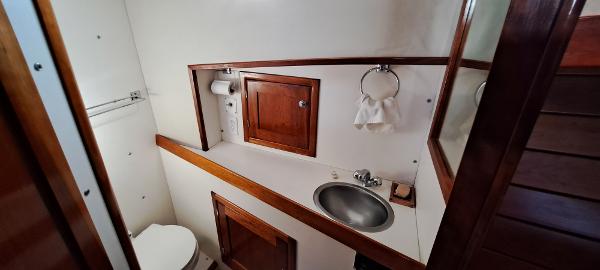 Slide: The Image of 1999 Rozema Boat Works Custom 42 bathroom with sink, toilet, and wooden cabinets. - 13