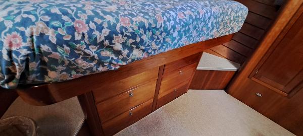 Slide: The Image of Interior cabin of 1999 Rozema Boat Works Custom 42 with floral bedspread and wooden drawers. - 15