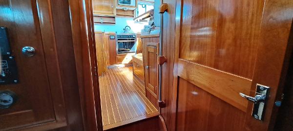 Slide: The Image of Interior of 1999 Rozema Boat Works Custom 42, featuring wooden cabinetry and flooring. - 17