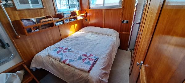 Slide: The Image of Cozy bedroom in 1999 Rozema Boat Works Custom 42 with wooden interior and quilted bedspread. - 20