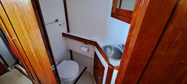Slide: The Image of 1999 Rozema Boat Works Custom 42 bathroom with wooden cabinetry and stainless steel sink. - 21