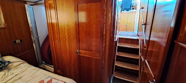 Slide: The Image of Interior of 1999 Rozema Boat Works Custom 42 with wooden cabinetry and stairs. - 24