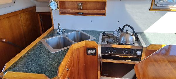 Slide: The Image of 1999 Rozema Boat Works Custom 42 kitchen with dual sink, stove, and wooden cabinetry. - 7
