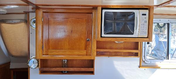 Slide: The Image of Interior of 1999 Rozema Boat Works Custom 42 with wooden cabinetry and microwave. - 8