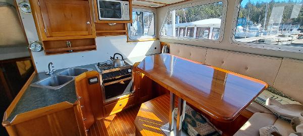 Slide: The Image of 1999 Rozema Boat Works Custom 42 interior with kitchen and dining area. - 9