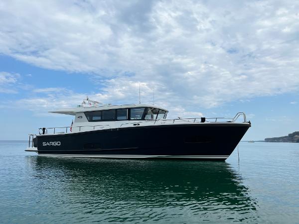 Slide: The Image of 2023 Sargo 45 boat on calm water under a partly cloudy sky. - 0