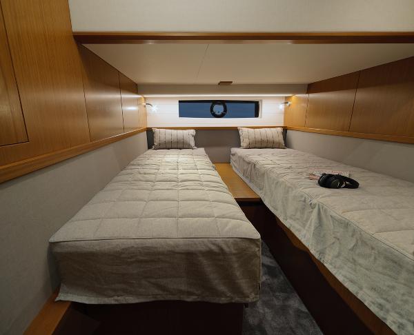 Slide: The Image of Interior of 2023 Sargo 45 boat cabin with twin beds and wooden accents. - 14