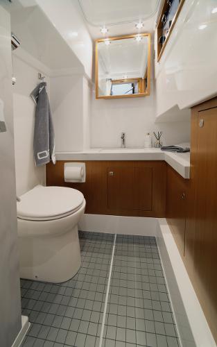Slide: The Image of Modern bathroom in 2023 Sargo 45 boat with toilet, sink, and wooden cabinets. - 16