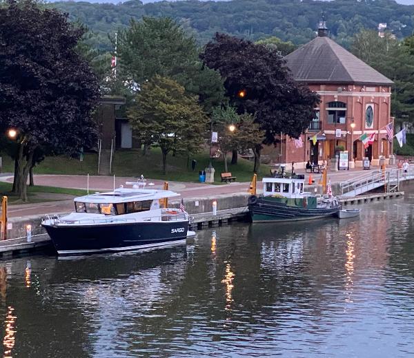 Slide: The Image of 2023 Sargo 45 boat docked near a historic building by a calm river. - 22