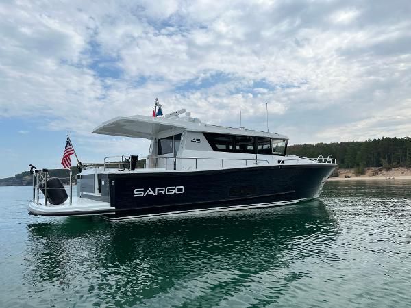 Slide: The Image of 2023 Sargo 45 boat on calm water with scenic background. - 24