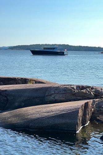 Slide: The Image of Sargo 45 boat cruising on a serene lake with rocky shoreline, 2023 model. - 31