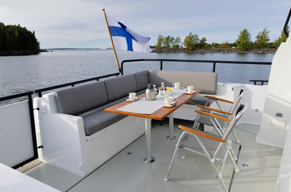 Slide: The Image of Sargo 45 Cat A 2025 boat deck with seating, table, and Finnish flag. - 10