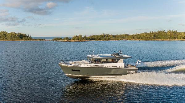 Slide: The Image of Sargo 45 Cat A 2025 motorboat cruising on a serene lake with forested shoreline. - 7