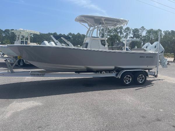 Slide: The Image of 2024 Sea Born LX 24 boat on a trailer in a parking lot. - 1