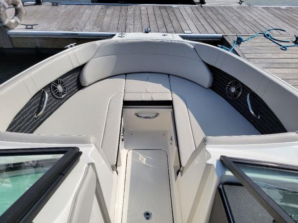 Slide: The Image of 2023 Sea Ray 230 SPX boat interior with cushioned seating and storage compartment. - 2