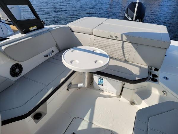Slide: The Image of 2023 Sea Ray 230 SPX boat interior with seating and table, docked on water. - 5