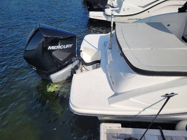 Slide: The Image of 2023 Sea Ray 230 SPX boat with Mercury outboard engine docked in water. - 8
