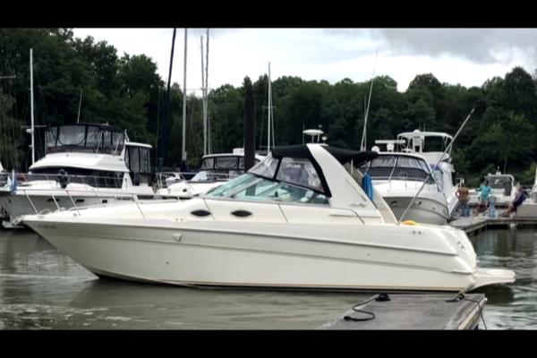 Slide: The Image of 1998 Sea Ray 290 Sundancer docked at marina with other boats. - 1