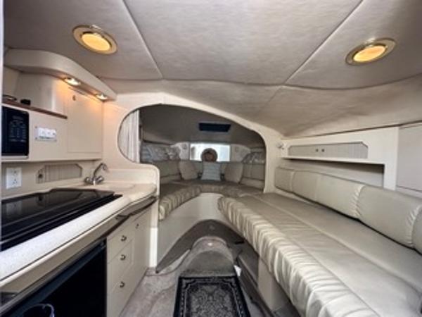 Slide: The Image of Interior of 1998 Sea Ray 290 Sundancer with kitchenette and seating area. - 14