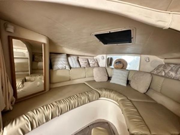 Slide: The Image of Interior cabin of 1998 Sea Ray 290 Sundancer with beige seating and pillows. - 15