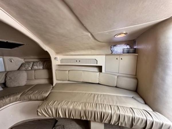 Slide: The Image of 1998 Sea Ray 290 Sundancer cabin interior with beige seating and storage cabinets. - 16