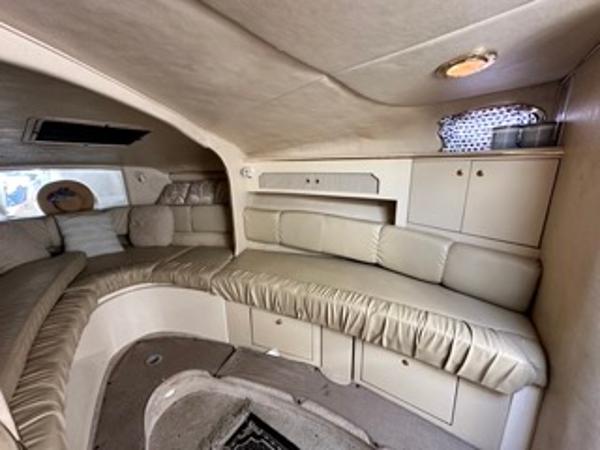 Slide: The Image of Interior of 1998 Sea Ray 290 Sundancer boat with beige seating and storage cabinets. - 17