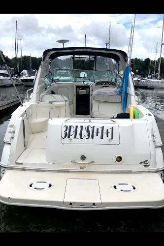 Slide: The Image of 1998 Sea Ray 290 Sundancer docked at marina, rear view with open cockpit. - 2
