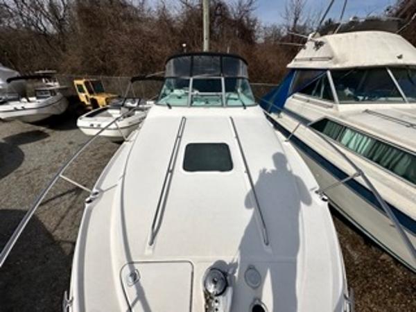 Slide: The Image of 1998 Sea Ray 290 Sundancer boat docked among other vessels. - 24