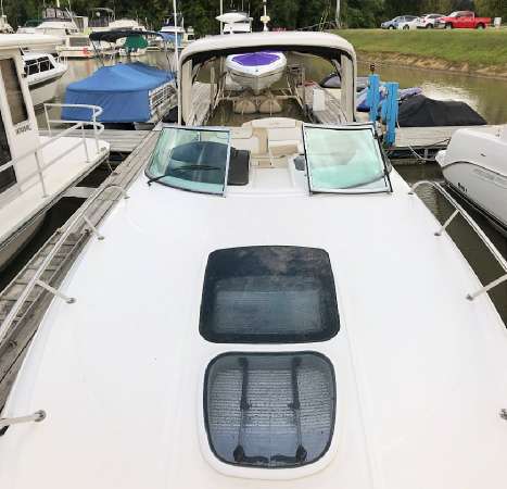 Slide: The Image of 2013 Sea Ray 310 Sundancer docked, showcasing sleek design and spacious deck. - 6