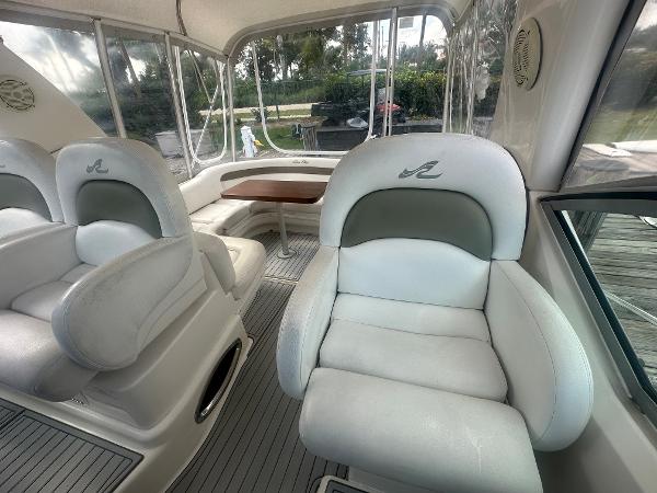 Slide: The Image of 2006 Sea Ray 340 Sundancer interior with white leather seating and a wooden table. - 26