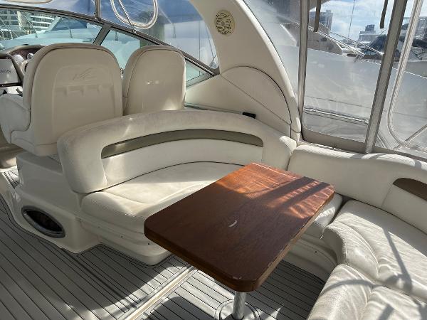 Slide: The Image of Interior of 2006 Sea Ray 340 Sundancer with white seating and wooden table. - 38
