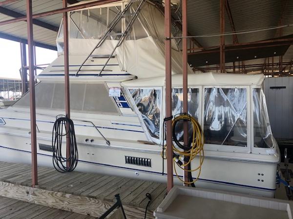 Slide: The Image of 1983 Sea Ray 390 Sport Fisherman docked in a covered marina. - 0