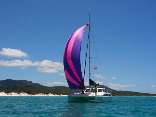 Slide: The Image of 2024 Seawind 1160 Lite sailing in clear blue waters with vibrant spinnaker. - 10
