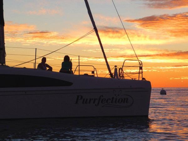 Slide: The Image of 2024 Seawind 1160 Lite catamaran Purrfection at sunset with people on deck. - 12