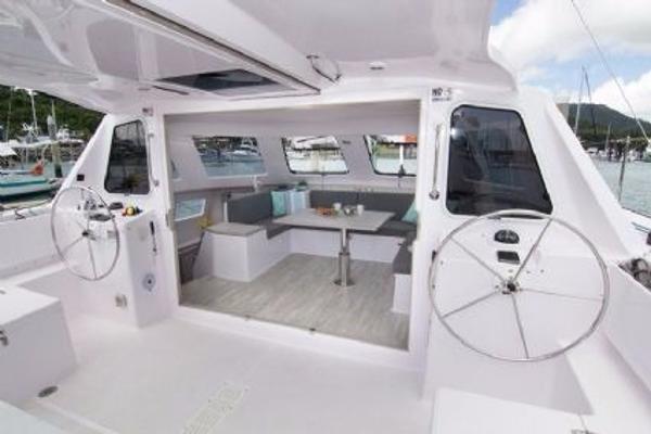 Slide: The Image of 2024 Seawind 1160 Lite yacht interior with dual steering wheels and spacious seating area. - 18