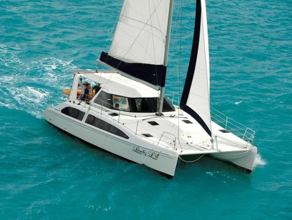 Slide: The Image of 2024 Seawind 1160 Lite catamaran sailing on turquoise waters. - 2