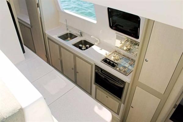 Slide: The Image of Modern kitchen in 2024 Seawind 1160 Lite catamaran with stove, sink, and ample storage. - 23