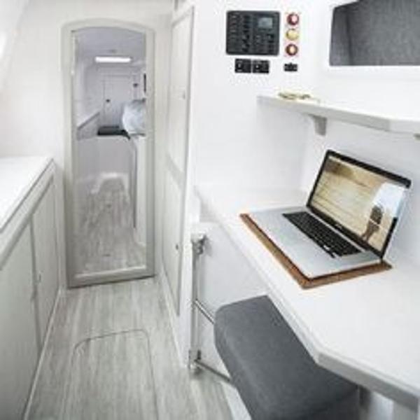 Slide: The Image of 2024 Seawind 1160 Lite interior with workspace and laptop. - 24