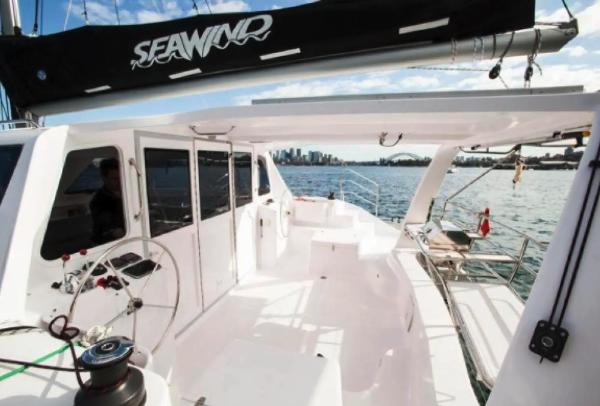 Slide: The Image of 2024 Seawind 1160 Lite catamaran, spacious deck with city skyline in the background. - 3