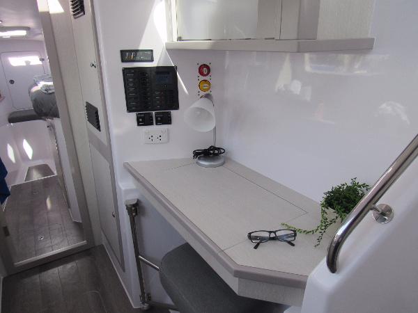 Slide: The Image of 2024 Seawind 1160 Lite interior workspace with desk, control panel, and modern decor. - 37