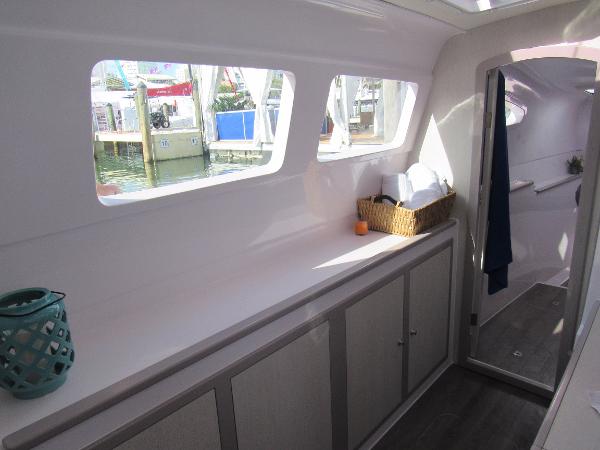 Slide: The Image of Interior of 2024 Seawind 1160 Lite catamaran with windows, cabinets, and decor. - 38