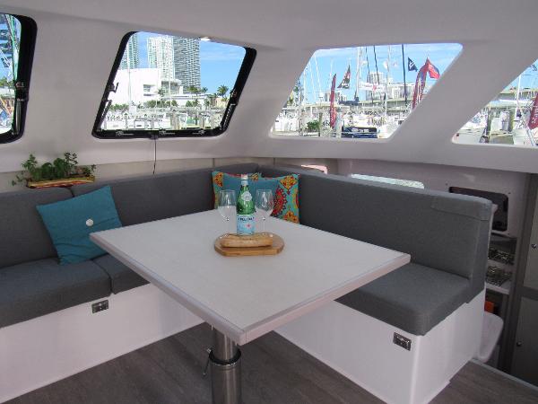 Slide: The Image of Interior of 2024 Seawind 1160 Lite catamaran with modern seating and marina view. - 40