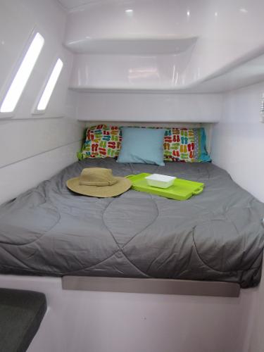Slide: The Image of 2024 Seawind 1160 Lite cabin with bed, pillows, hat, and tray. - 42