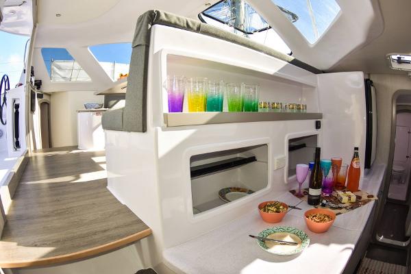 Slide: The Image of Interior of 2024 Seawind 1160 Lite catamaran with dining setup and colorful drinks. - 46