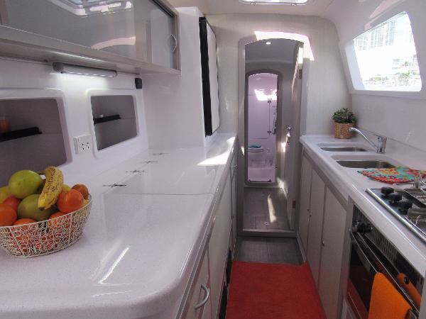 Slide: The Image of Modern kitchen interior of 2024 Seawind 1160 Lite catamaran with fruit basket and stainless steel appliances. - 47