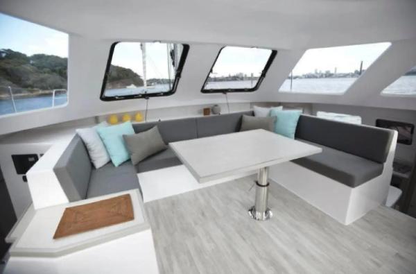 Slide: The Image of Interior of 2024 Seawind 1160 Lite catamaran with modern seating and table. - 5