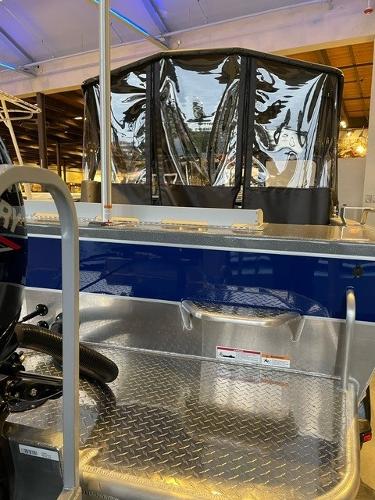 Slide: The Image of 2024 Spartan 185 Astoria boat interior with diamond plate flooring and protective canopy. - 9